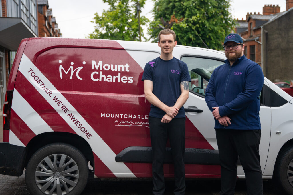 2 members of Mount Charles food team posing in front of the Mount Charles branded van
