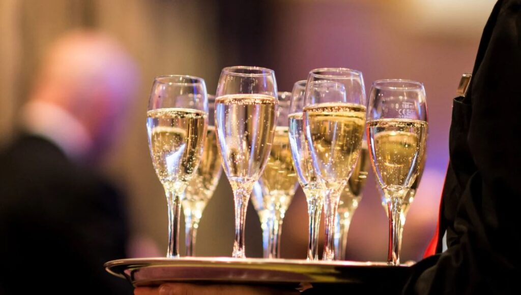 A server carries a try of champagne flutes