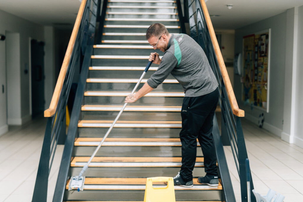 Cleaner mopping a staircase