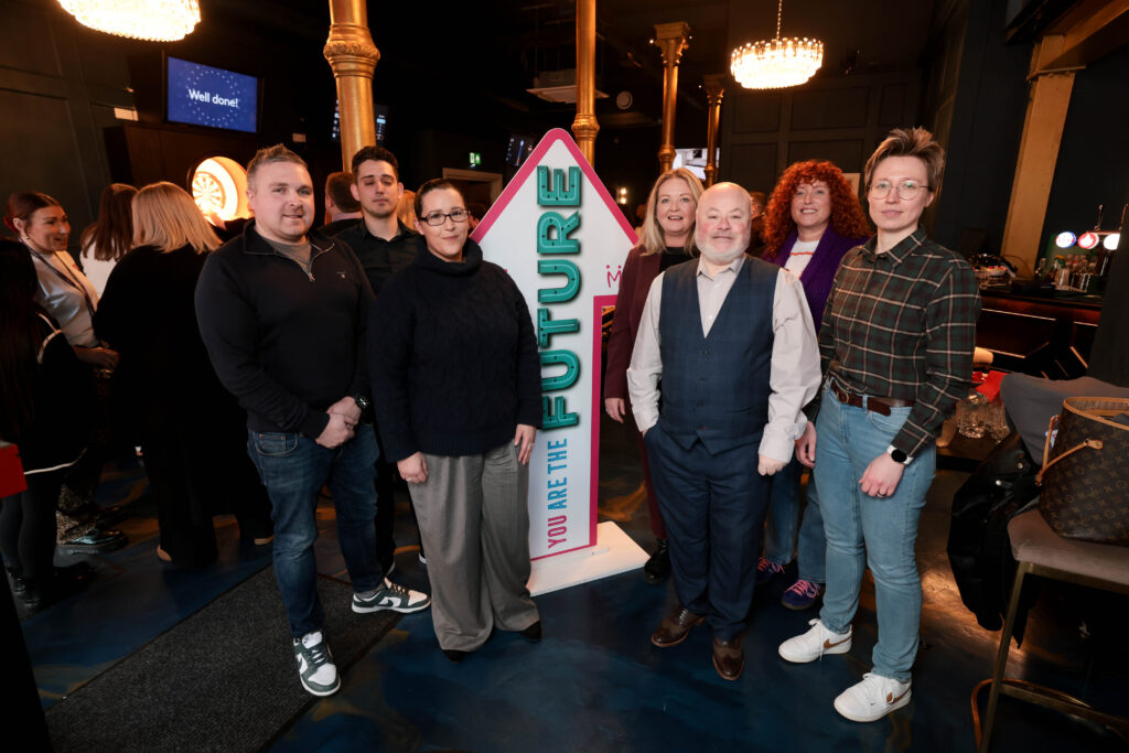 A variety of Mount Charles team members surrounding You are the Future arrow at Strategy Launch Day 2025