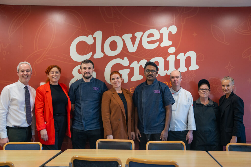 The Mount Charles IBTS team in front of Clover & Grain branding on launch day