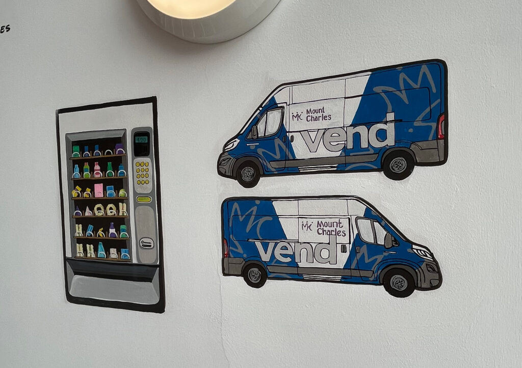 Vending machine and Mount Charles branded van painted on a white wall